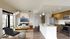 Chic open-concept living room and kitchen with modern decor, large windows, and sleek stainless steel appliances.