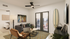 Chic modern living room with surfboard decor, comfortable seating, and natural light through large balcony doors.
