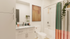 Elegant bathroom with modern fixtures, featuring a granite countertop vanity, stylish shower curtain, and lush potted greenery.