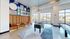 Chic modern lounge area with vibrant art, wall-length seating, and engaging games like foosball and shuffleboard, perfect for social gatherings.