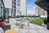 Modern apartment outdoor area with stylish seating, ping pong table, and lush greenery, perfect for leisure and socializing.