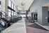 Modern, spacious gym with panoramic windows, featuring state-of-the-art exercise equipment and sleek design.