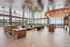 Luxurious modern lounge with panoramic windows, stylish wooden furnishings, and elegant seating area offering stunning city views.