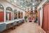 Chic modern lounge with elegant mirrors, stylish seating, and artistic ceiling design.