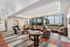 Modern apartment common area featuring plush seating, panoramic city views, and an elegant design with vibrant patterned carpeting.