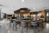 Luxurious modern lounge with sleek bar seating, multiple large TVs, and a chic open space for socializing.