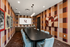 Elegant modern meeting room with a long black table, stylish blue chairs, and vibrant checkered wallpaper.