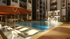 Luxurious apartment courtyard with a sparkling pool, comfortable loungers, and stylish seating areas, perfect for relaxation and socializing.