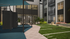 Modern apartment complex courtyard featuring a shaded seating area, vibrant greenery, and sleek architectural design.
