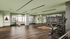 Modern and spacious gym with yoga mats, exercise bike, rowing machine, and an extensive collection of weights, designed for a premium fitness experience.