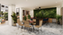 Modern communal lounge area with elegant dining table, lush green wall, and cozy seating under soft lighting.