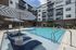 Luxurious apartment complex with stylish pool area, featuring modern amenities, comfortable loungers, and chic umbrellas for a perfect leisure experience.