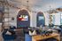 Modern lounge area with stylish seating, elegant geometric wall designs, and vibrant international flags creating a welcoming ambiance.