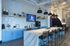 Modern communal kitchen with sleek marble countertops, stylish blue cabinetry, and elegant pendant lighting, perfect for entertaining.