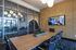 Modern conference room with elegant wood table, sleek black chairs, and vibrant geometric wall design.