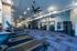 Modern, spacious gym featuring state-of-the-art treadmills, workout equipment, and stylish blue flooring.