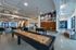 Modern common area with sleek design, featuring a shuffleboard table and vibrant artwork, perfect for socializing and relaxation.