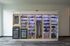 Innovative vending wall with illuminated shelves showcasing snacks, gadgets, and household items for convenient borrowing.