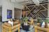 Modern lobby area at Atlas Blue Hill with stylish wooden chairs, green chairs, and geometric wall accents creating an inviting and professional atmosphere.
