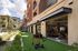 Modern apartment complex with an open-air gym, lush landscaping, and vibrant facade, offering a luxurious lifestyle.