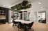 Modern dining area with natural light, featuring a sleek table, designer chairs, and stylish pendant lighting. Indoor greenery enhances the inviting atmosphere.