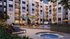 Luxurious apartment complex featuring a serene pool, modern outdoor seating, and stylish balconies.