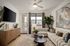 Elegant living room with a cozy sectional sofa, large TV, and modern decor, featuring abundant natural light through a spacious window.