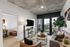 Bright and modern living space with city views, featuring cozy seating, chic decor, and a spacious balcony.