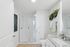 Elegant bathroom with a sleek glass shower, modern vanity, and stylish greenery accents.