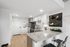 Modern kitchen with sleek cabinetry and granite countertops, complemented by cozy bar seating and stylish decor.