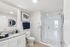 Modern bathroom featuring a sleek glass shower, elegant granite countertop, and stylish decor with national parks artwork.