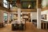Modern apartment lounge with high ceilings, elegant marble countertops, and chic seating areas, bathed in natural light.