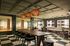Luxurious communal space featuring chic pendant lighting, elegant wooden dining table, and comfortable seating areas with modern d&eacute;cor.