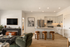 Chic open-concept living space with modern kitchen, stylish bar stools, and cozy seating area.