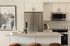 Modern kitchen with sleek stainless steel appliances, elegant white cabinetry, and a stylish island featuring minimalist decor.