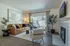 Chic and cozy living room with a modern leather sofa, elegant decor, and a fireplace, opening to a serene outdoor area.