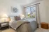 Cozy and inviting bedroom featuring a plush, sunlit area with modern decor, soft bedding, and elegant lamps.