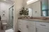 Bright and elegant bathroom featuring modern cabinetry, a sleek countertop, and a refreshing shower area.