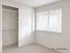 Bright, spacious room with plush carpeting, an open closet, and a large window inviting natural light.
