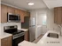 Modern kitchen with sleek stainless steel appliances, elegant wood cabinetry, and convenient in-unit laundry room.