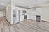 Dog-Friendly Apartments in Brooklyn Park, MN - Urbana Court Apartments - Bright Open Kitchen With White Cabinets, Stainless Steel Appliances, And Gray Wood Look Flooring.