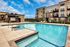 Modern Studio Apartments in Brooklyn Park, MN - Urbana Court Apartments - Outdoor Resort-Style Swimming Pool With Shallow Sun Shelf, Pool Ladder, And Lounge Chairs.