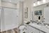 Brooklyn Park, MN, Pet-Friendly Apartments - Urbana Court Apartments - Spacious Bathroom With Barrier-Free Shower, White Vanity With Granite Countertop, Large Mirror, And Modern Light Fixtures.