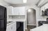 North Las Vegas, NV, Apartments Near Las Vegas Strip - Topaz Springs - Modern Kitchen With White Cabinets, A Black Refrigerator, Stainless Microwave, And Gas Range.