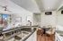 Apartments in North Las Vegas for Rent - Desert Ridge - Galley Kitchen with White Cabinetry, Grante Countertops, Wood Plank Flooring, and All White Appliances
