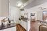 KitchenStudio Apartments in North Las Vegas, NV - Desert Ridge Apartments - Open Kitchen With Breakfast Bar, Granite Countertops, White Cabinets, Electric Stove, and Wood Flooring.