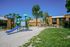 Playground Dog-Friendly Apartments in North Las Vegas, NV - Desert Ridge Apartments - Playground With Slide, Shade Canopies, Open Lawn, and Apartment Homes Nearby.