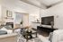 Aurora, CO, Apartments Near Downtown Denver - Silverbrook - Bright Living Room Featuring Dark Wood Floors, Cozy Fireplace, Wall-Mounted TV, And An Open Breakfast Bar Into The Kitchen.