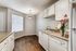 Aurora, CO, Apartments Near Cherry Creek State Park - Silverbrook - Galley-Style Kitchen With White Cabinets, Double Sink, Track Lighting, And Matching White Appliances.