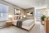 Aurora, CO, Apartments Near Anschutz - Canterra at Fitzsimons - Bright Bedroom With Upholstered Bed, Patterned Pillows, Bedside Lamps, Large Window With Blinds, Soft Carpet, and Dresser.